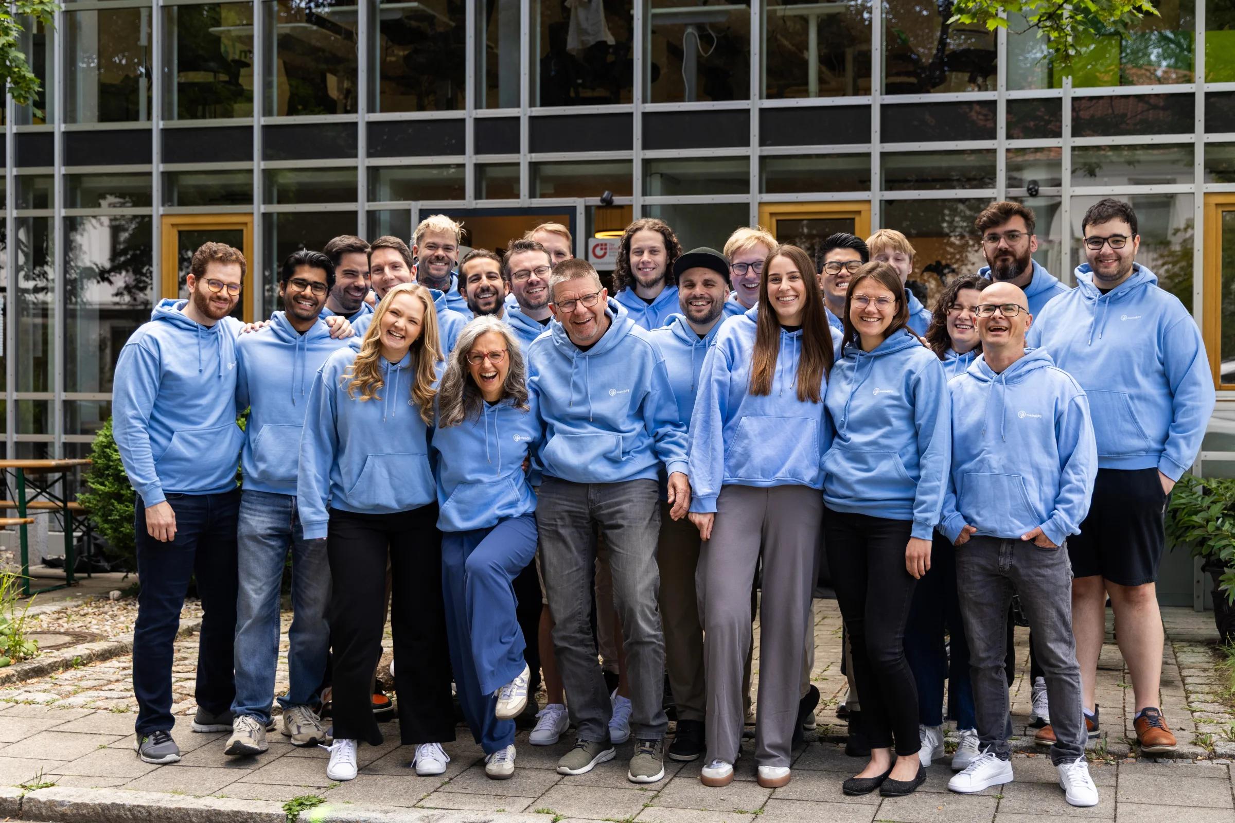 Das MeinGPT-Team in hellblauen Pullovern vor dem Büro